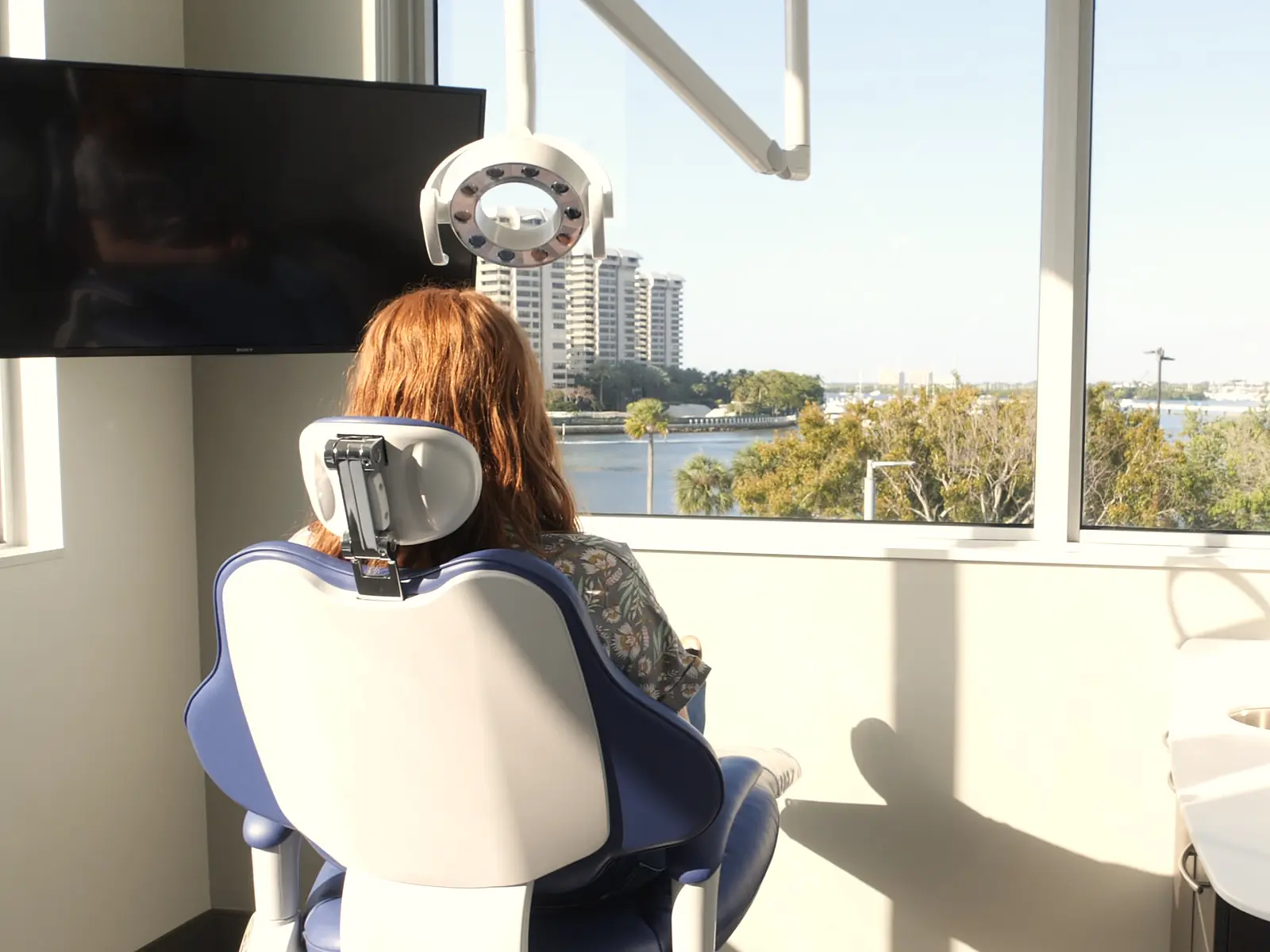 A patient in the treatment chair at Vizcaya Dental Arts, looking out over Biscayne Bay