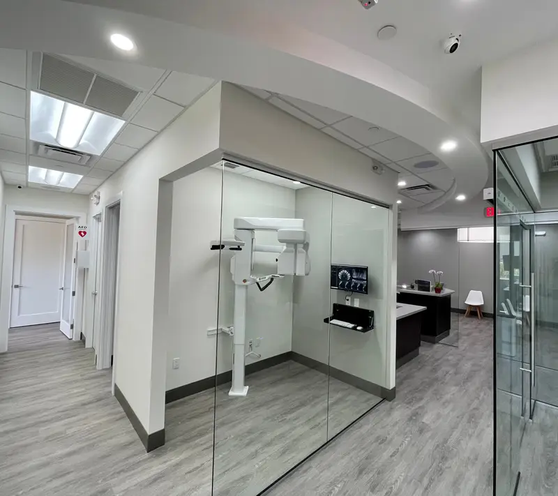 The cone-beam CT scanner in its glass-walled room at Vizcaya Dental Arts