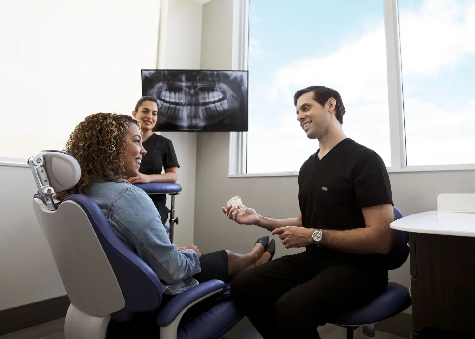 Dr. Kottar explaining a treatment plan to a patient with a dental model